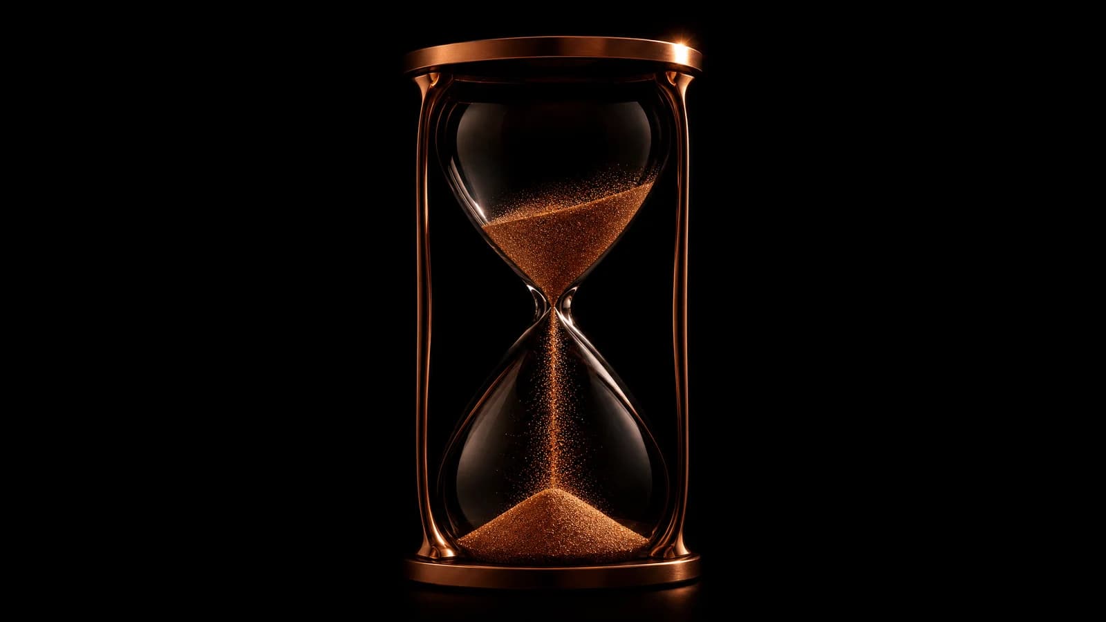 A copper hourglass with luminous sand on black